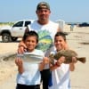 Padre Eli Peralda of Humble helped sons Kevin and christian catch these nice trout and flounder.