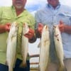 John Haynes and Mark Jaminson of Dayton, TX heft just a few of their speckled trout they caught on soft plastic.