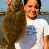 Erica Adams of Huntsville, TX hefts a nice flounder caught on shrimp.