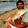 Andre Jones puckers up for this 25 inch slot red he caught on shrimp.