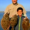 Father and son, Ron and Logan Linton of Humble, TX show their early morning flounder catch caught on mud minnows.