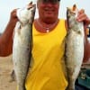 Dennis Boeker of High Island, TX hefts 4 and 5 lb specks caught on plastic.