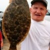 Hughy Singleton of Winnie, TX hefts this nice flounder he caught on a finger mullet.