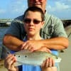 Father and son, Kieth Cox of Austin, TX hugs his son Adam for catching and releasing his very first rat red caught on shrimp.
