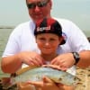 Family friend Lee Brading of Vidor TX helps 12 yr old Wesley Fant with his nice sand trout he caught on shrimp-