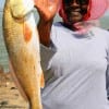 Monica Neal of Houston hefts this nice 25 inch slot red caught on a finger mullet