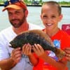 Father and son, Jason Hall hugs up on 9 yr old Brad who caught this nice flounder on a finger mullet