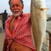 Crystal Beach TX angler Dwaine Taylor hefts this 28 inch slot red caught on a finger mullet