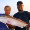 Lenard Hebert and wife Mora heft this huge 37 inch tagger bull red that he caught at night on cut croaker