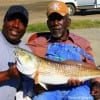 Father and Son, Calvin and Melvin Smith show off dads 30 inch Tagger Bull Red he caught on a finger mullet