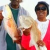Fishing couple Paul and Mary Mayfield of Houston show off 2 of their 6 slot reds they caught on live shrimp