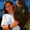 Beckie Greys of Gilchrist TX hefts this HUGE 23 inch doormat flounder caught on Berkley Gulp