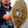Chad H. of Houston hefts this nice flatfish caught on a finger mullet
