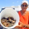 Rollover angler Henri Fontenot holds his Bucket-O-Crab Claws he wrangled up from catching 19 Stone Crabs