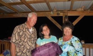 Papa Ted and Brenda Cannon Henley with granddaughter Callie Grace Collins celebrating her birthday on the ranch. Papa Ted had found her a purple silk sleeping bag fit for a PNG high school student that delighted the receiver.
