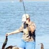 Lady wade angler hooks up on a flounder