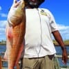 Retired Army Sgt Albert Cunningham of San Antonio hefts this nice 36inch tagger bull red caught on cut mullet