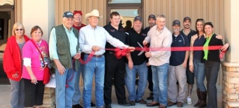 Billy Flowers cutting the ribbon, with Advanced Electronics associates and  Chamber of Commerce members looking on.