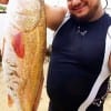 Cesar Mendoza of Conroe TX hefts this 28inch slot red caught on squid