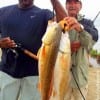 Rollover anglers Ralph Spiller and Henri Fontenot share their stringer of reds and specks they took on soft plastics