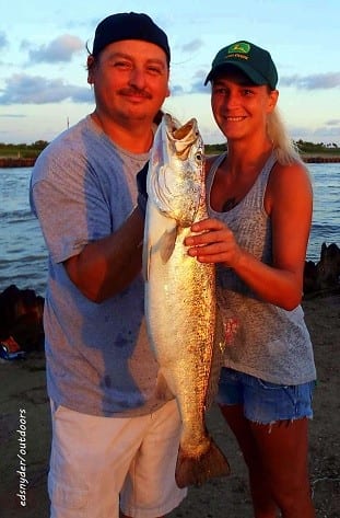 My BIGGEST FISH EVER, informed an excited Bobbi Darby, seen here being helped by her hubby Jason hefting this 27inch 6.5 lb gator-trout