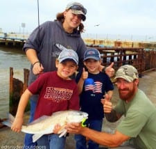 Baycliff angler Damon Carter is given a big thumbs up by his family after he caught his 24inch slot red on berkely gulp