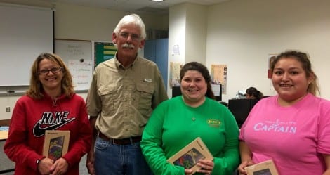 Tom Osten, TCFC President, presenting internet tablets to students completing GED Preparation Classes; from left to right: Rentia Mathis, Tonja Billiot and Maria Botello. Not pictured is Thomas Meals.