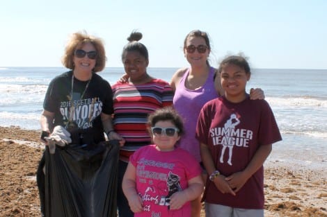 Teacher and Leo Club Advisor Janie Prather pitching in to help the students clean the beach