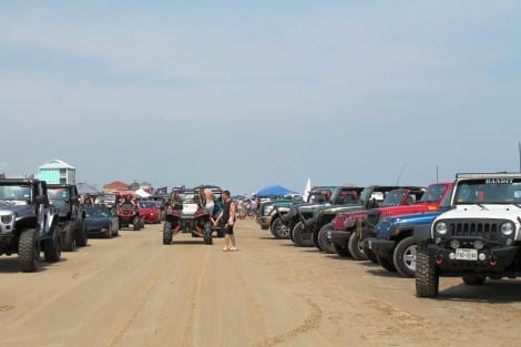 Jeeps and jeep owners (along with other miscellaneous vehicles) lined both sides of the driving lane on the beach.