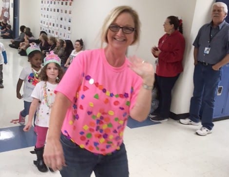 Parade Marshal Elaine Rollfing, wearing her shirt with 100 buttons, leads the students to celebrate the 100th Day of School.
